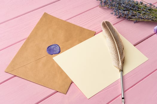 Envelope with letter on pink wooden background top view photo