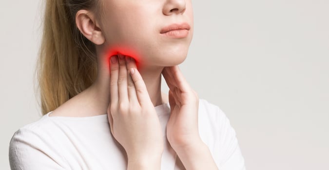 Woman with thyroid gland problem, touching her neck, closeup, panorama photo