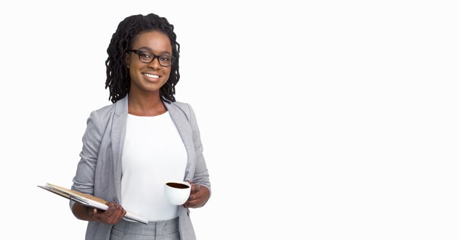 Confident African American woman entrepreneur wearing a grey jacket and glasses, holding coffee cup and papers, isolated on a white background, with ample space for copy. photo