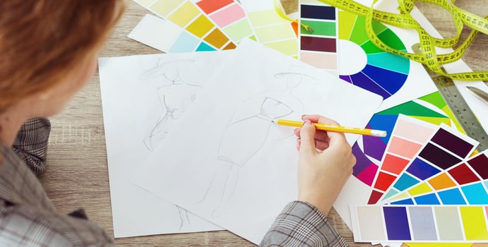 Fashion designer drawing new sketches, working on new collection in atelier, panorama photo