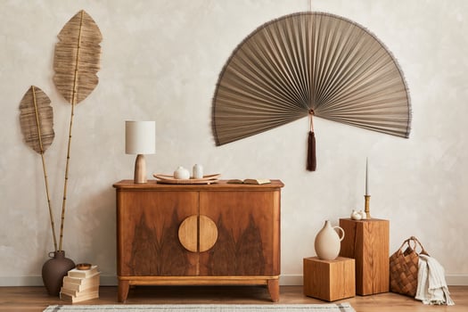 Japandi concept of living room with design wooden commode, table lamp, tropical dried leaf in vase, cubes, decoration, japanese fan and elegant personal accessories in home decor. Template. photo