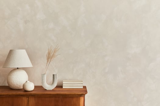 Minimalist composition of living room with wooden commode, table lamp, dried flower in vase, book, decoration and elegant personal accessories in stylish home decor. Copy space. photo
