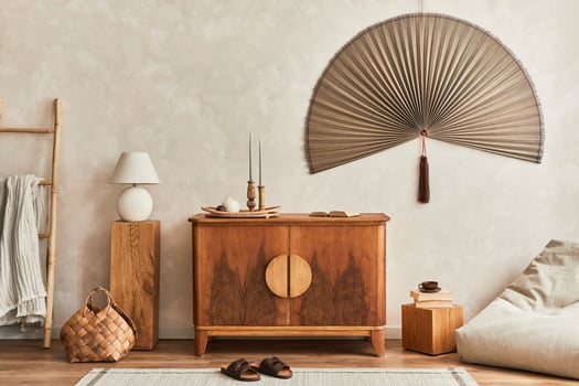 Japandi concept of living room with wooden commode, table lamp, tropical dried leaf in vase, cubes, decoration, japanese fan and elegant personal accessories in home decor. Template. photo