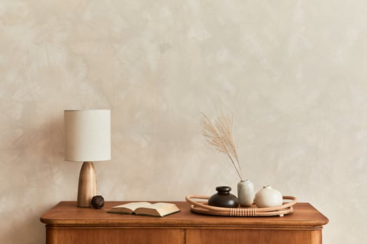 Minimalist composition of living room with commode, table lamp, dried flower in vase, book, decoration and elegant personal accessories in stylish home decor. Template. Copy space. photo