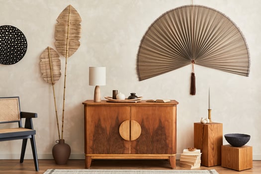 Japandi concept of living room with design wooden commode, table lamp, tropical dried leaf in vase, cubes, decoration, japanese fan and elegant personal accessories in home decor. Template. photo