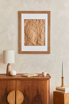 Interior design of neutral living room with stylish retro commode, mock up poster frame, cube, table lamp, decoration and personal accessories in home decor. Template. Japandi concept. photo