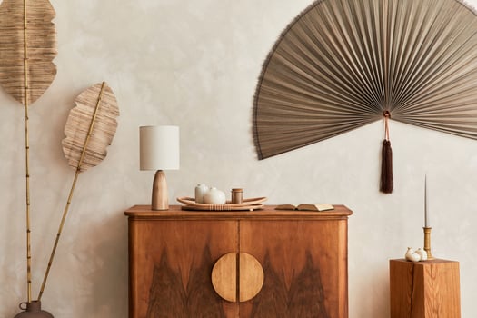 Japandi concept of living room with design wooden commode, table lamp, tropical dried leaf in vase, cubes, decoration, japanese fan and elegant personal accessories in home decor. Template. photo