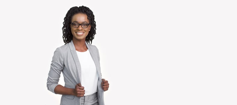 Assured African American professional woman donned in a grey blazer and eyeglasses, isolated on a white background, wide frame with copy space for text. photo