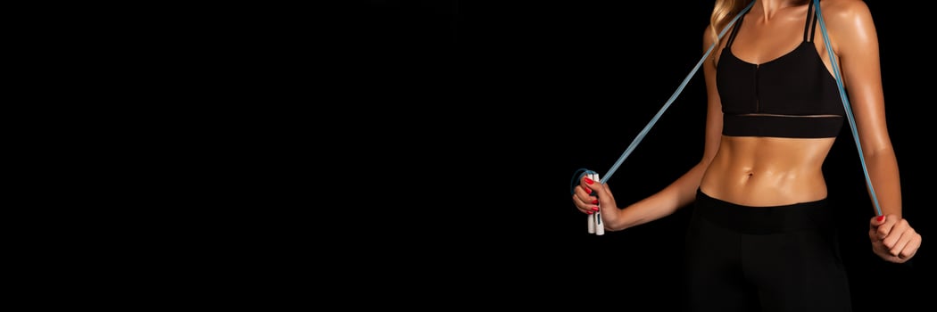 Unrecognizable Lady Holding Jump Rope On Black Studio Background. Fitness Lifestyle Concept. Free Space, Cropped photo