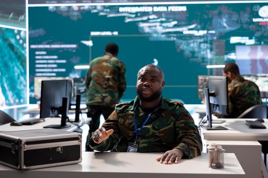 Professional military officer participates in a secure call online, leveraging high tech computer systems in modern operation room to coordinate intelligence and mission planning for defense. photo
