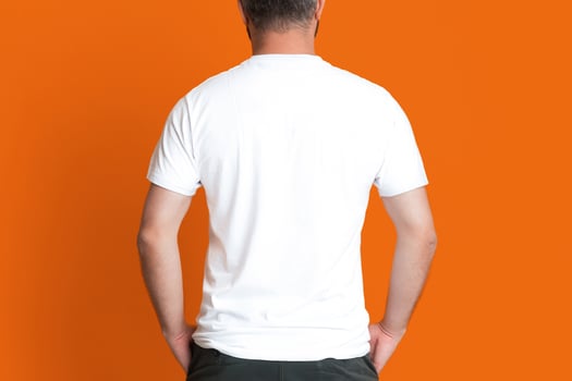 Back view of man wearing a white shirt and black pants is standing in the image, looking straight ahead. He appears calm and confident in his attire, exuding a professional vibe. photo