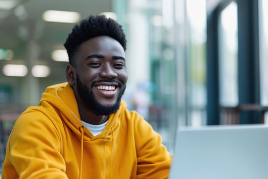 cheerful young African male student participates in online training at his workstation photo