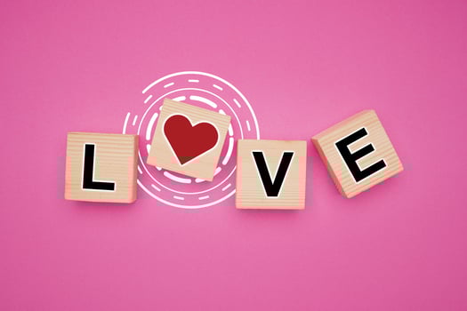 Wooden cube elements with letters LOVE and red heart icon isolated pink background photo