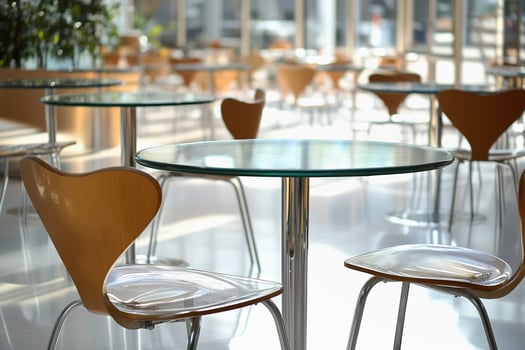 Stylish glass tables and wooden chairs create an inviting atmosphere in a spacious cafeteria photo