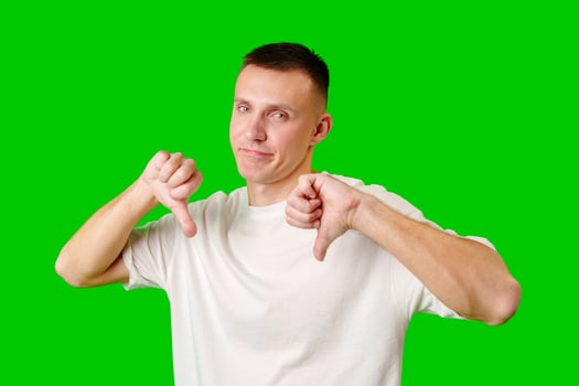 Young Man Making Disapproving Gesture Against Bright Green Background photo