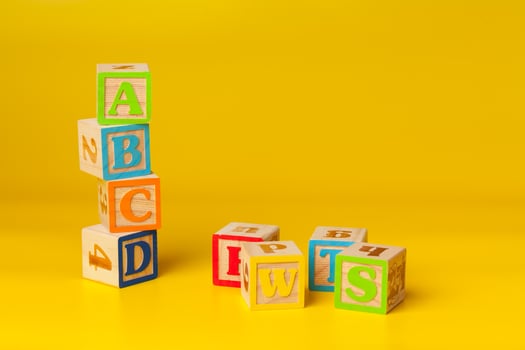 Colorful wooden blocks with letters on a yellow color background photo