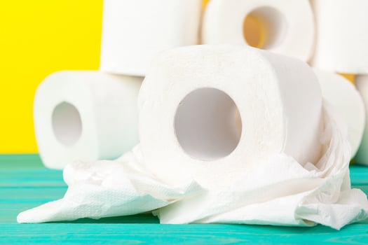 Toilet paper rolls stacked against yellow paper background photo