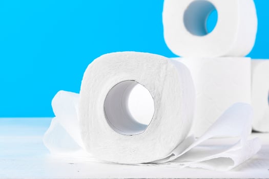 Toilet paper rolls stacked against blue background photo