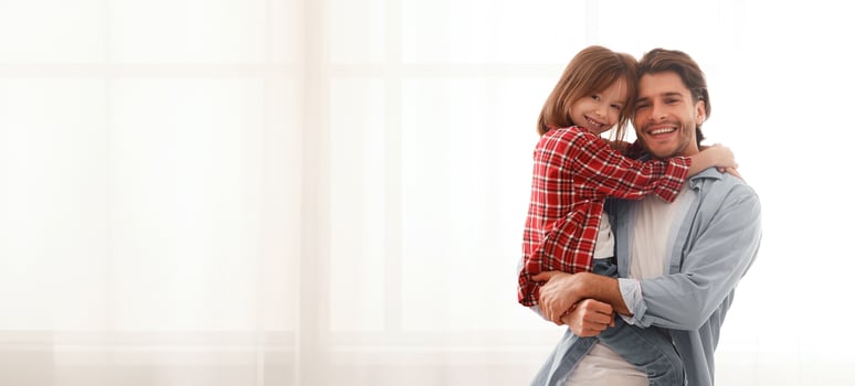 Smiling daddy and daughter posing at home over big window, copy space photo