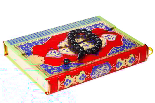 Islamic Book Holy Quran and beads on withe background photo