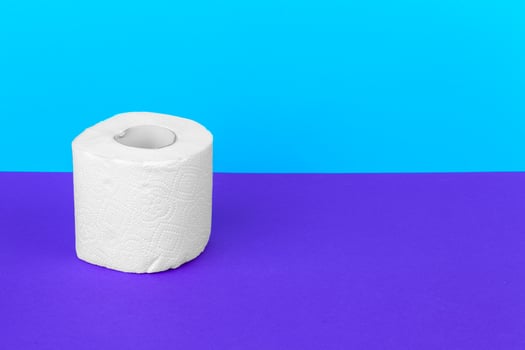 Toilet paper isolated on white table with blue background. Cleaning concept product photo