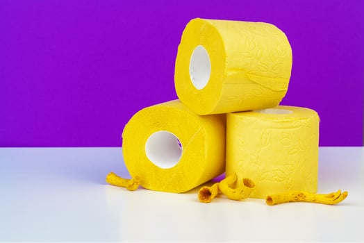 Minimalistic composition of bright yellow toilet paper rolls on purple background photo