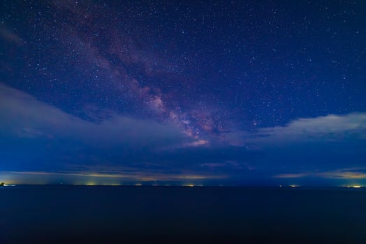 starry night sky over large mountain lake at night photo