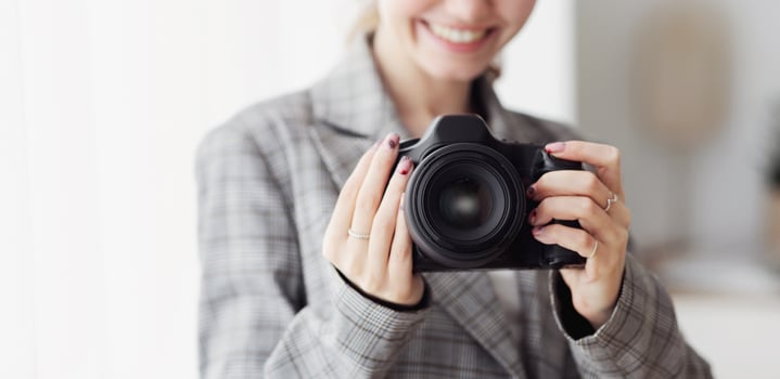 Female Photographer Taking Photo With Professional Photo Camera In Her Office
