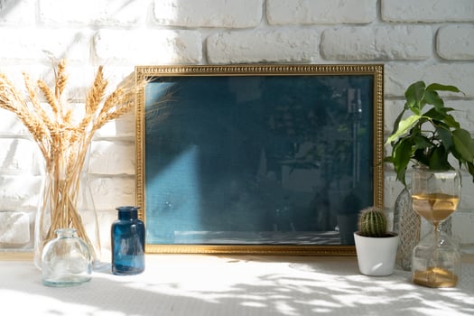 Mockup with a frame and dry flowers in a vase on a white table photo
