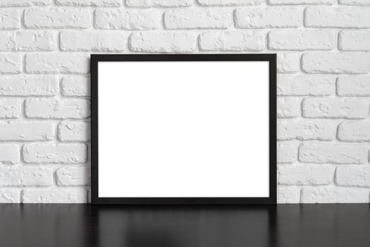 Blank picture frame against brick wall with copy space photo