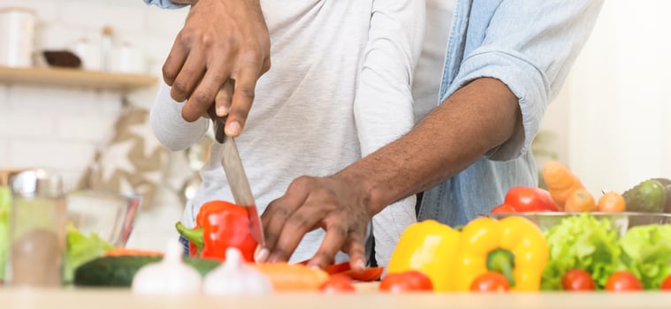 An African American father diligently preps vegetables, symbolizing nutritious family meals and the role of fatherhood in the kitchen photo