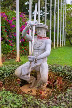 Statue in a flower bed, plants around it photo