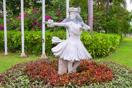 Statue in a flower bed, plants around it photo