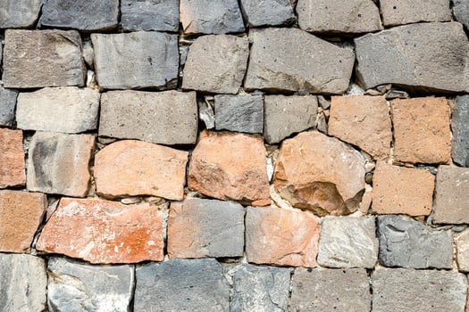 wall from red and black tuff stones photo
