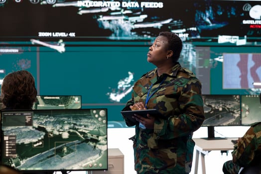 Woman army captain overseeing special reconnaissance mission in command center headquarters, undertaking operations of intelligence gathering with CCTV military satellite footage. photo