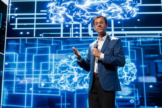 Expert talking at AI tech summit event gathering professionals seeking to discover latest AI solutions across different industries. Man presents how can AI be leveraged to accelerate innovation photo