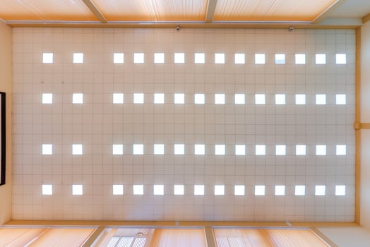 cassette stretched or suspended ceiling with square halogen spots lamps and drywall construction in empty room in house or office. Looking up view photo