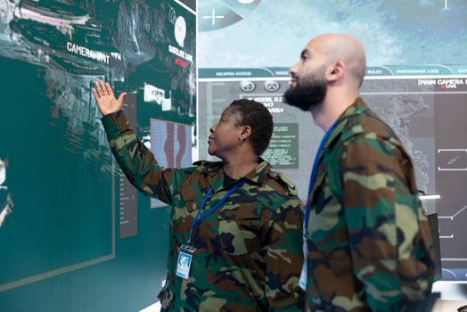 Man and woman monitoring real time information on a big screen in command center army base. Military engineers following warships trajectory in central office, support infantry unit. photo