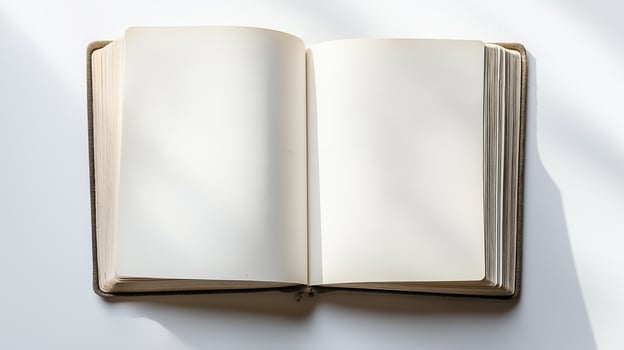 An open blank notebook with clean white pages, lying flat on a surface, illuminated by soft natural light photo