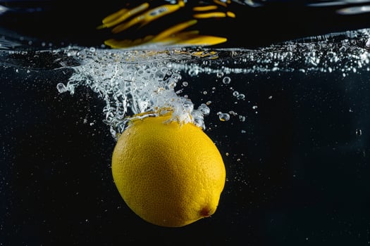 A lemon is being splashed into the water photo