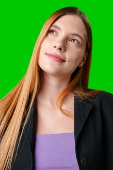 Young Woman Wearing Black Blazer and Purple Top Against Green Screen photo