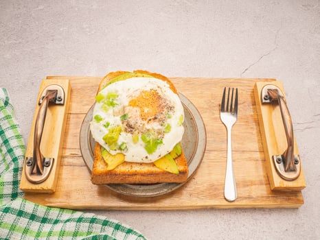 Toast with avocado and egg served on a wooden tray photo