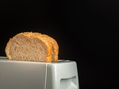 Rich and soft whole wheat bread in the toaster with a black background photo