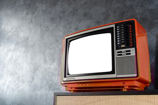 A retro television with a blank screen sits in a room. An old, orange television set is turned off, clipping path. photo
