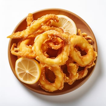 A plate of fried squid rings with lemon slices photo