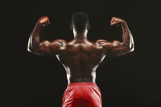Muscular Athletic Bodybuilder Fitness Model Posing After Exercises, Back View photo