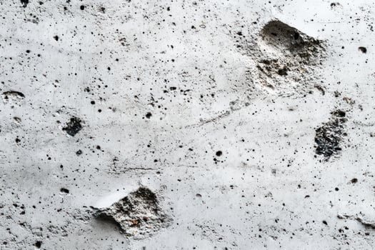 Close-up of a White Concrete Wall with Irregular Holes photo