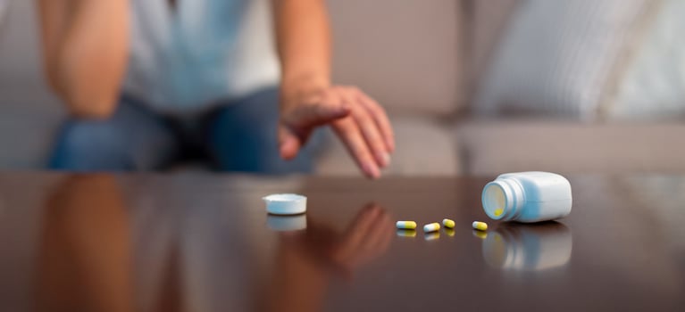 Suicide. Unrecognizable Girl Reaching For Antidepressant Or Sleeping Pills Sitting On Couch Indoor. Panorama, Cropped, Selective Focus photo