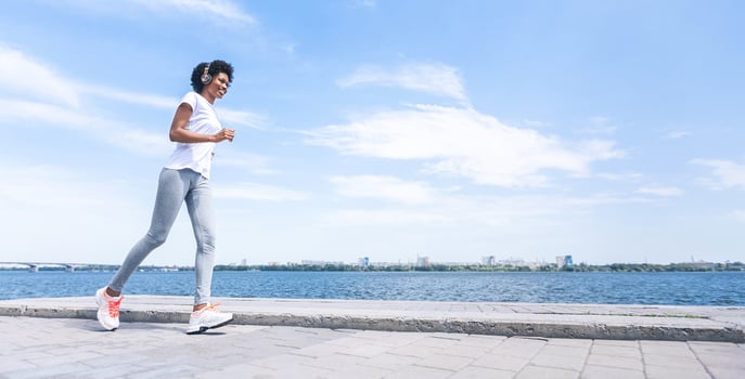 African American Woman Jogging Along River Bank In City. Morning Run Concept. Panorama, Free Space photo
