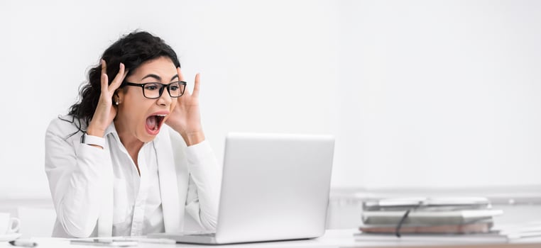 Shocking News. Amazed mexican businesswoman looking at laptop computer with open mouth and eyes. Copy space photo